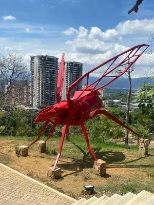 Escultura de la hormiga culona en un parque de Bucaramanga, representando la vigilancia y precisión que caracterizan a los detectives privados en Bucaramanga, con la ciudad de fondo como escenario de investigación.